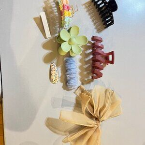 Assorted hair accessories inside a fluffy pink heart shaped pouch with a zipper